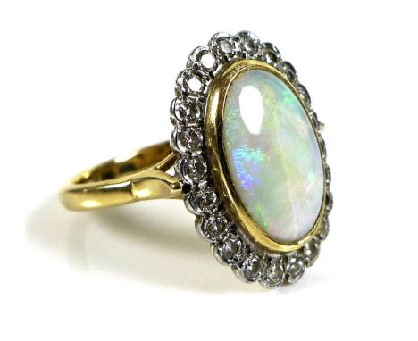 An 18ct gold, opal and diamond ring, oval opal 13.2 by 8.8mm, surrounded by twenty two diamond brilliants, size O, 6g. 