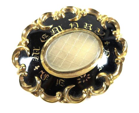 A 14ct gold and black enamel Victorian mourning brooch, set to the centre with an oval engraved mother-of-pearl plaque, surro