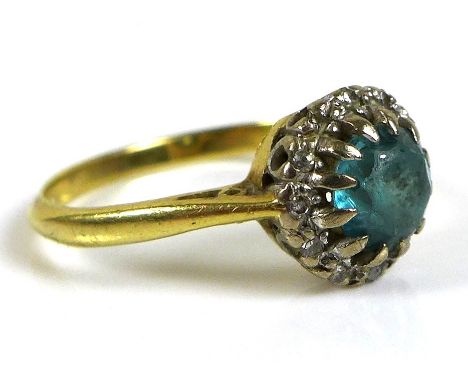 An 18ct gold blue topaz style stone and diamond ring, the round cut central blue stone of approximately 5mm in diameter, surr