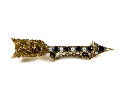 A 10ct gold arrow brooch set with sapphires and seed pearls, with the Greek letters for Pi Beta Phi on the fletching, 2.8cm l
