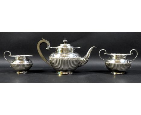 A George V three piece silver tea service, of ovoid form with part reeded lower bodies and decorative rims, floral clasped ha