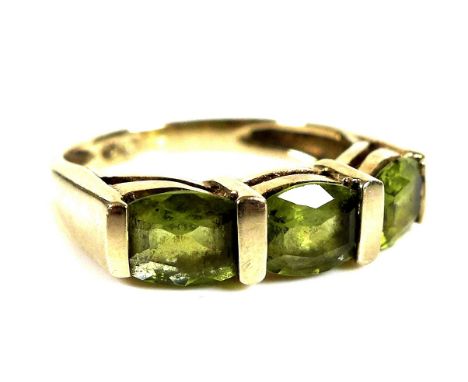 A 10ct gold ring set with three peridots, each stone of approximately 0.4ct, 4.4 by 4.8mm approximately, size N, 3.3g. 