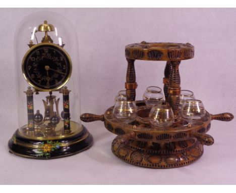 A DOME TOP ANNIVERSARY MANTEL CLOCK with painted ebonised detail and a wooden musical maritime themed drink dispenser