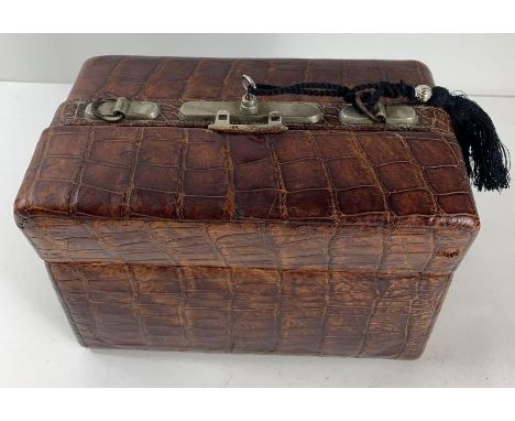 A late 19th/early 20th century gentleman's travelling toiletry case, in brown crocodile; containing four jars/vessels with si