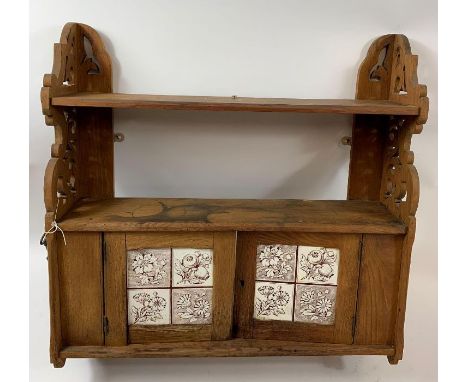 A 20th century oak hanging unit, set with two ceramic tiles each depicting plants and flowers, 65cm high, 61cm long, 16cm dee