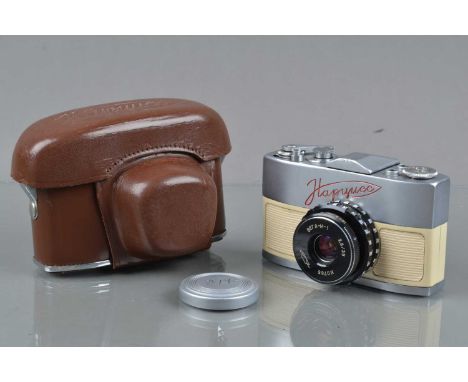 A KMZ Narciss 16mm Camera, white, shutter not fully cocking, body G, with 35mm f/2.9 lens, elements G-VG, with cap, two rings