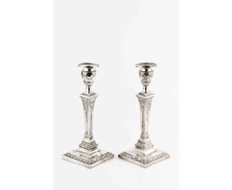 A pair of late Victorian silver candlesticks, of neo-classical design, the tapering square section columns decorated with rib