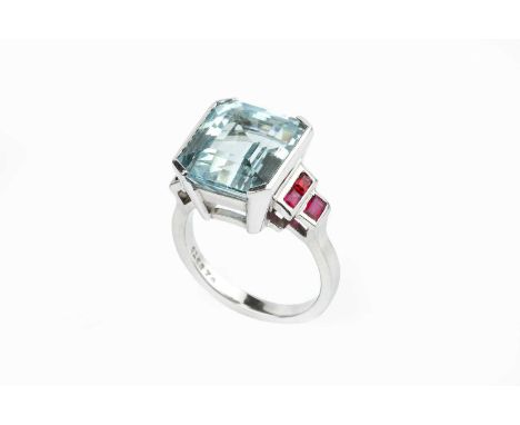 An aquamarine and ruby dress ring, the octagonal step-cut aquamarine in raised part-collet setting, between stepped shoulders