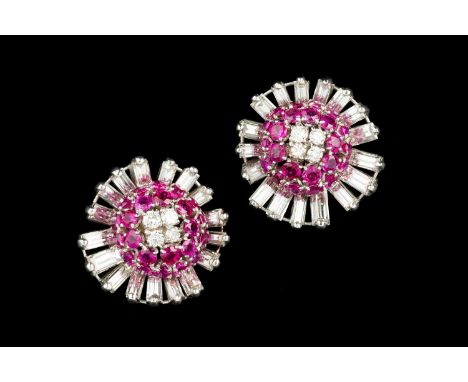 A pair of ruby and diamond cluster ear clips, each designed as a stylized flowerhead, centred with a bombé cluster of graduat