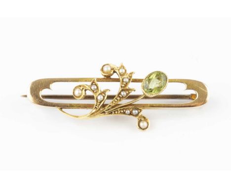 A peridot and half pearl panel brooch, the elongated oval openwork panel applied with a foliate spray of half pearls, accente