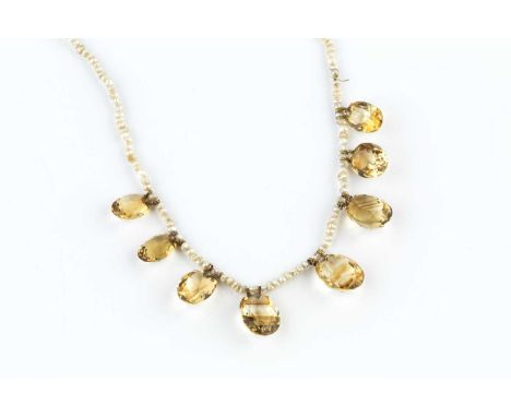 A citrine and seed pearl fringe necklace, the fringe of graduated oval mixed-cut citrines suspended from a seed pearl single 