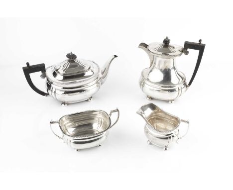 A silver four piece tea service, with gadrooned borders, the teapot and hot water pots with ebonised handles and knops, by Ma