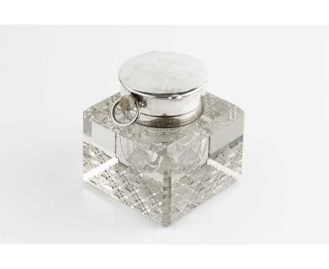 An Edwardian silver mounted large cut glass inkwell, the hinged top fitted with a keyless wind pocket watch, with enamel dial