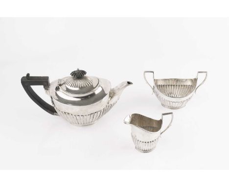 An Edwardian silver bachelor's three piece tea service, with half lobed bodies, the teapot with ebonised handle and knop, 13.