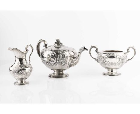 An early Victorian silver three piece tea service, embossed and chased with flowering foliage and 'C' scrolls, the teapot wit