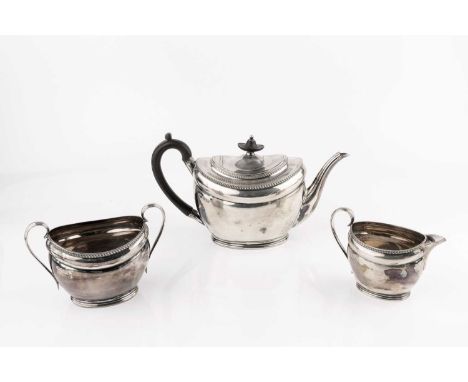 An Edwardian silver three piece tea service, of oval form, with gadrooned borders, the teapot with ebonised handle and knop, 