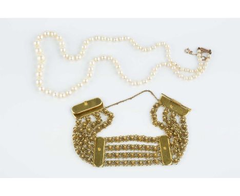 An Eastern yellow metal panel bracelet, designed as a series of shaped rectangular panels, interspersed with four chain-link 