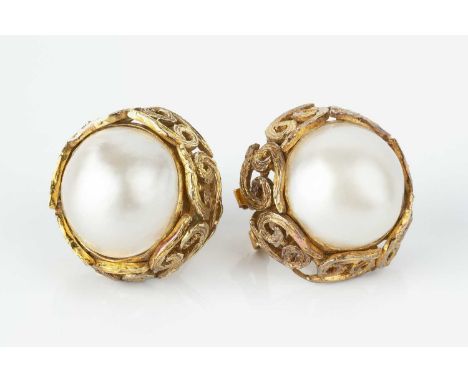 A pair of mabe pearl ear studs, each mabe pearl inset within a border of textured scrolls, on post and hinged clip fittings, 