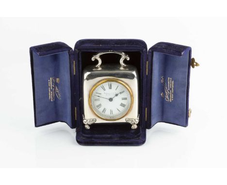 An Edwardian silver cased mantel timepiece, of rounded square design, with scroll handle, and white enamel dial, on scroll an