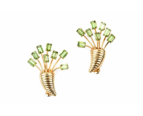 A pair of gem set ear clips, each designed as a cornucopia, issuing a spray of rectangular step-cut green gemstones, on hinge