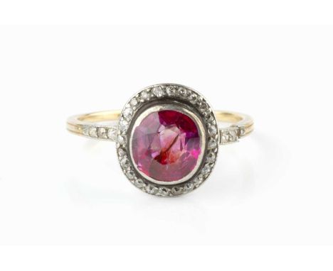 A ruby and diamond cluster ring, the cushion-shaped mixed-cut ruby collet set within a border of old and single-cut diamonds,