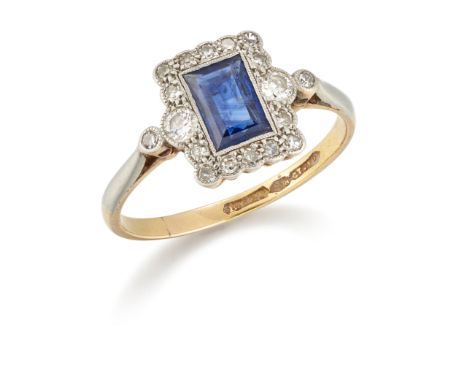 An early 20th century gold sapphire and diamond cluster ring, the rectangular step-cut sapphire to surround of brilliant-cut 