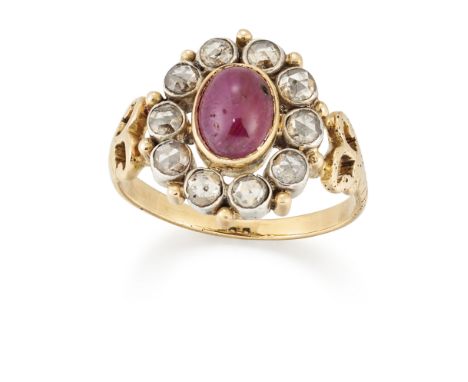 A ruby and diamond cluster ring, the oval cabochon ruby to surround of circular-rose-cut diamonds, with scroll shoulders and 