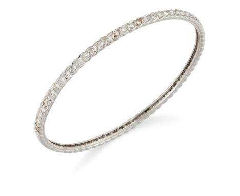 A diamond set bangle, a row of brilliant-cut diamonds (four diamonds deficient), grain set to foliate settings, internal diam