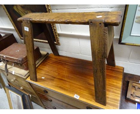A rustic vintage pine trestle stool