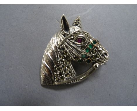 A silver and marcasite horse brooch inset with ruby eyes