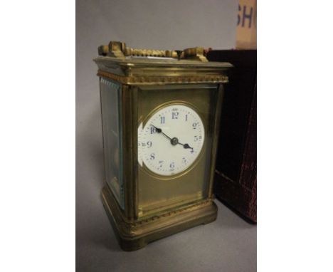 19th century Gilt Brass Travelling Carriage Clock, the white enamel dial with Blue and Black Arabic Numerals, with Key, conta