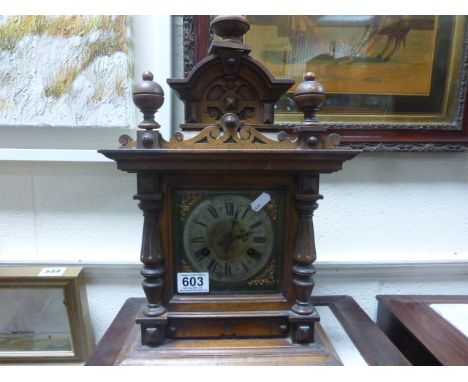 An oak cased antique mantle clock of classical form with two train movement and brass face raised on a plinth base.