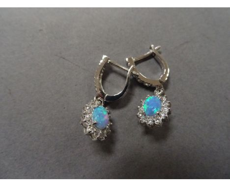 A pair of silver, cz and blue opal earrings
