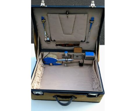 A vintage ladies travel case with blue enamel and chrome vanity accessories and canvas cover 