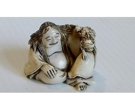 A late 19th /early 20th century Japanese netsuke of a seated man with frog, signed to base, without damage or repair 
