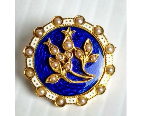 An Edwardian yellow gold, blue and white guilloche enamel circular brooch with seed pearl border and floral spray to centre, 