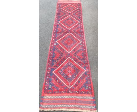 An Afghan burgundy-ground Meshwani hand-knotted wool runner with multicoloured isometric decoration in good condition, light 