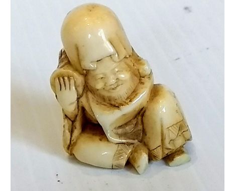 A late 19th /early 20th century Japanese netsuke of a seated man, chipped, signed to base, a 19th century ivory carved letter