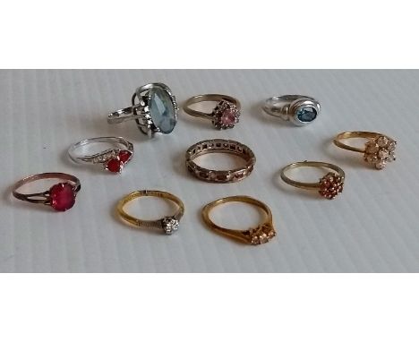 An assortment of ten 9ct yellow and white gold rings adorned with spinels, white sapphires, white topaz, fire opal, etc., all
