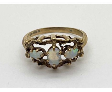 A 9ct Gold Opal Three Stone Ring, the claw set stones between highly decorative openwork setting and tapered band (finger siz