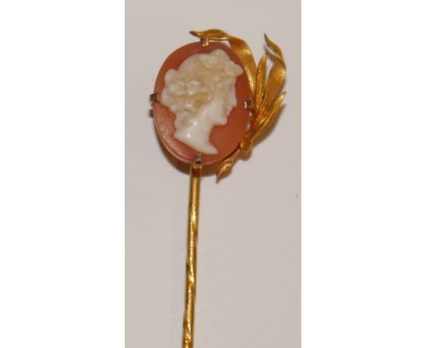 A shell cameo stick pin, oval portrait of a maiden facing left, half wrapped with leaves, gold mounts and pin, spiralled shaf