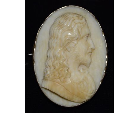 An early 19th century Dieppe ivory brooch, profile portrait of Christ facing left. yellow metal frame, 43mm x 30mm, unmarked,