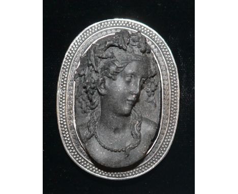 A lava and silver portrait brooch, bust of a classical maiden facing left, cast silver coloured metal frame, unmarked, 56mm x