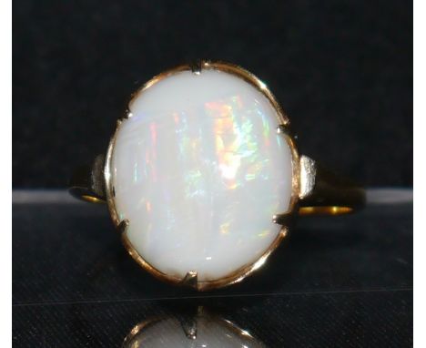 An opal ring,  large oval opal, flashing blue, red, orange and green colour play, 14ct gold shank, size L, 3.2g gross