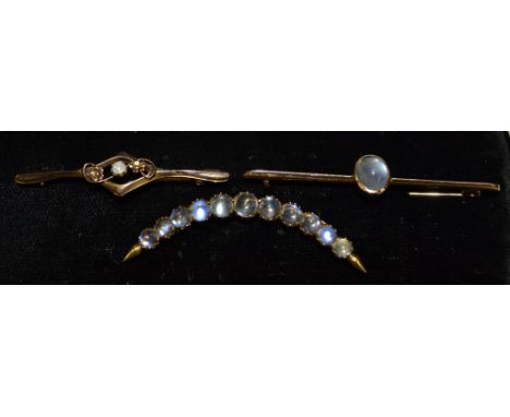 A moonstone crescent brooch, set with eleven graduating round moonstone cabochons, yellow metal mount and pin;  another singl