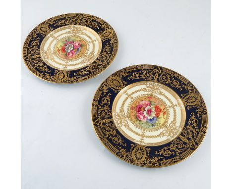 Two Royal Worcester cabinet plates, decorated with flowers by Freeman, to a deep blue border with gilt decoration, diameter 1