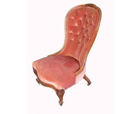 A Victorian Grandmothers Chair, with Button back upholstery, carved foliate decoration and raised on carved cabriole and knur