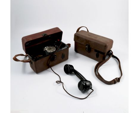 Two cased GPO field telephones, in brown plastic cases and leather straps, together with a reel of cable