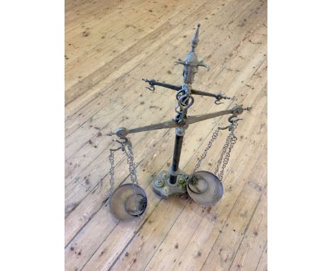 A set of brass floor standing balance scales, with bull mask to the top, two sets of two pans suspended on chains, fitted wit