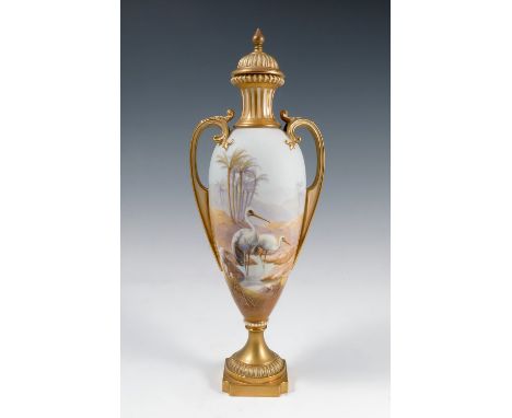 A Royal Worcester covered vase, decorated all around with storks in a desert landscape, having two gilt hoop handles, shape n